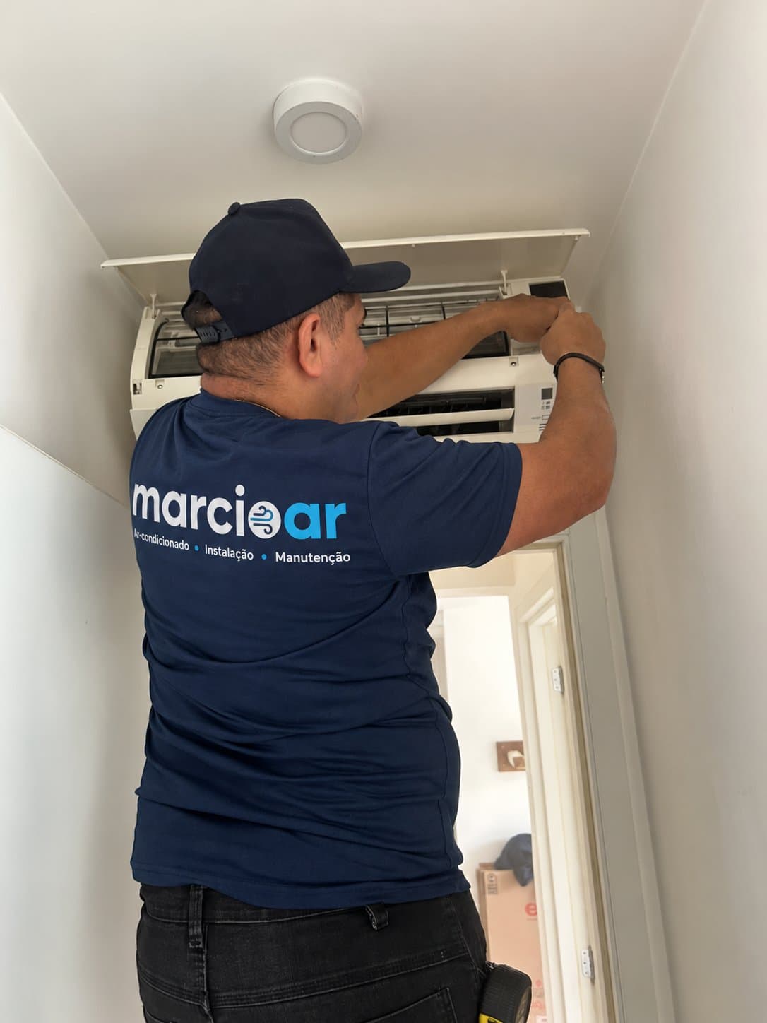Técnico abrindo o ar-condicionado para a higienização completa